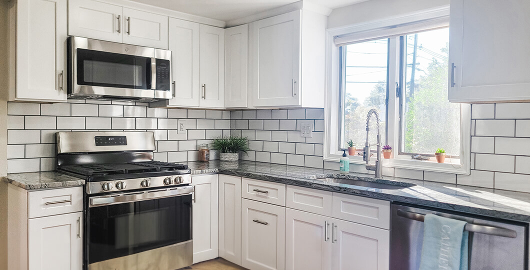 Small kitchen with white cabinets and white subway tile backsplash